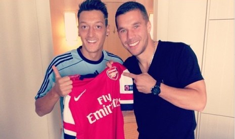 Mesut Oezil memegang jersey Arsenal bersama rekannya, Lukas Podolski