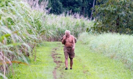 Michael Fomenko berjalan di antara ladang tebu dalam sebuah foto yang diambil pada tahun 1990-an.