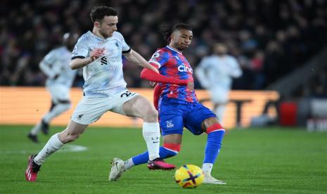 Michael Olise dari Crystal Palace (kanan) beraksi melawan Diogo Jota dari Liverpool selama pertandingan sepak bola Liga Utama Inggris antara Crystal Palace dan Liverpool FC di London, Ahad (26/2/2023) dini hari WIB.