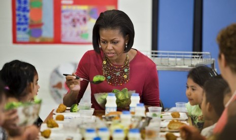 Michelle Obama mendampingi anak-anak makan di sekolahnya saat menggagas program makan sehat.