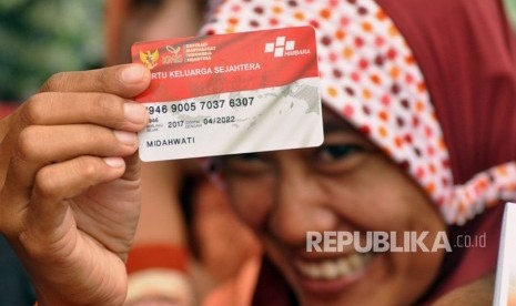 Midahwati, salah satu penerima manfaat Program Keluarga Harapan menunjukkan Kartu Keluarga Sejahtera yang baru diterimanya, di SMKN 1 Kajen, Kabupaten Pekalongan, Senin (15/1). 