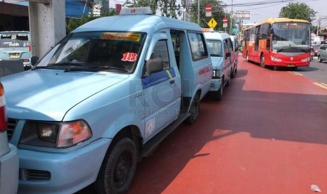 Mikrolet mengantri menunggu penumpang di Terminal Kampung Melayu hingga menutupi jalur Transjakarta, Jakarta Timur, Jumat (4/7).(Republika/Rakhmawaty La'lang)