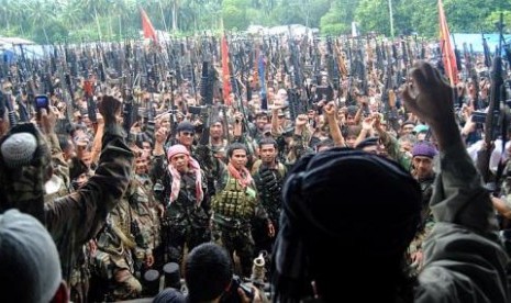 Milisi Front Pembebasan Nasional Moro (MNLF) mengangkat senjata saat mencapai kesepakatan damai dengan pemerintah Filipina pada 1996.