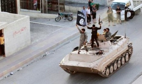 Militant Islamist fighters take part in a military parade along the streets of northern Raqqa province June 30, 2014.