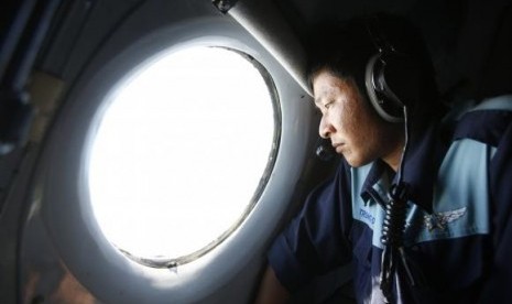 Anggota militer Nguyen Tran melihat ke luar dari dalam pesawat AL Vietnam AN-26 dalam misi mencari pesawat Malaysia Airlines yang hilang MH370 di pulau Con Dao pada 14 Maret 2014.