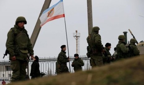 Military personnel stand guard in the Crimean port city of Feodosiya March 2, 2014.