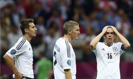 Miroslav Klose (kiri), Bastian Schweinsteiger (tengah), dan Philipp Lahm tampak kecewa setelah Jerman menelan kekalahan 1-2 dari Italia di semifinal Piala Eropa 2012. 