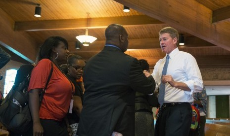 Missouri State Attorney General Chris Koster (R) greets parishioners after speaking about the need for law enforcement and the communities they police to work together better during church services at the Greater St Mark Family Church as the community disc