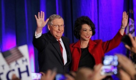 Mitch McConnell waves to supporters with his wife, former United States Secretary of Labor Elaine Chao, at his midterm election night rally in Louisville, Kentucky, November 4, 2014.