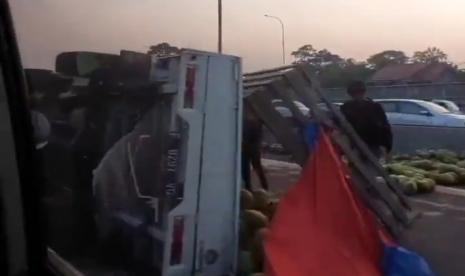 Mobil bak terbuka pengangkut kelapa terguling di Tol Jagorawi.