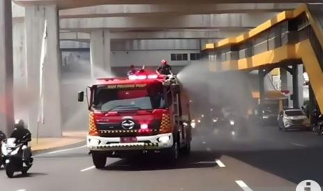 Mobil dari Sudin Penanggulangan Kebakaran dan Penyelamatan (Gulkarmat) Jakarta Timur tengah melakukan penyemprotan air untuk mengurangi dampak polusi udara di Jalan MT Haryono, Cawang, Jakarta Timur, Jumat (25/8/2023). 