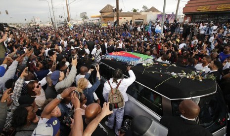 Mobil jenazah membawa mendiang rapper Nipsey Hussle yang dibungkus bendera asal ayahnya, Eritrea di Afrika Timur, melewati jalanan, Kamis (11/4) waktu Los Angeles. 