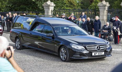 Mobil jenazah yang membawa peti mati Ratu Elizabeth II, terbungkus Standar Kerajaan Skotlandia, melewati Aberdeen, Skotlandia, Minggu, 11 September 2022 saat melanjutkan perjalanannya ke Edinburgh dari Balmoral.