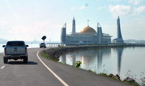 Mobil melintasi Masjid Al-Alam, Kota Kendari, Sulawesi Tenggara. Hasil rapat pleno PWI Pusat dan Dewan Pers menetapkan Sultra sebagai tuan rumah HPN 2020. Ilustrasi.