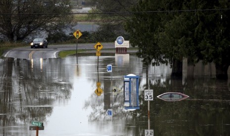 Mobil mendekati kawasan yang terkena banjir di kawasan Stanwood, Washington. Badai mengakibatkan banjir dan pemadaman listrik, Rabu (18/11).