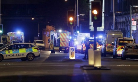 Mobil polisi terparkir di Jembatan London setelah insiden van yang menabrakkan kendaraannya di jalur pedesterian, Ahad (4/6).