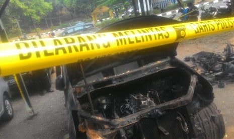 Mobil Xenia warna hitam Nopol B 1247 EKC terongok dan dipasang garis polisi di bengkel mobil di Jalan M Yasin, Kelapa Dua, Cimanggis, Depok. Mobil tersebut merupakan mobil milik Neno Warisman yang terbakar.