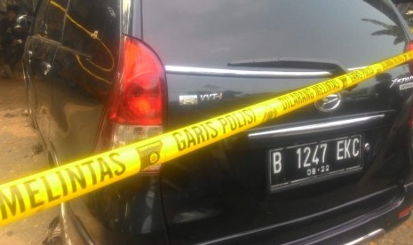 Mobil Xenia warna hitam Nopol B 1247 EKC terongok dan dipasang garis polisi di bengkel mobil di Jalan M Yasin, Kelapa Dua, Cimanggis, Depok. Mobil tersebut merupakan mobil milik Neno Warisman yang terbakar.