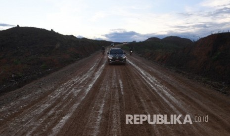 Dalam ayat (2) RUU IKN, pemerintahan khusus IKN dapat melakukan pemungutan pajak dan/atau pungutan khusus IKN. Foto: Mobil yang membawa Presiden Joko Widodo melewati jalan berlumpur saat meninjau lokasi rencana ibu kota baru di Sepaku, Penajam Paser Utara, Kalimantan Timur, beberapa waktu lalu.. 