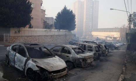 Mobil yang terbakar akibat kebakaran lahan di utara kota Haifa, Israel 24 November 2016. 