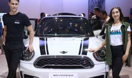 Model berfoto di samping mobil New MINI Cooper Countryman seusai peluncuran di ajang pameran otomotif Gaikindo Indonesia Internasional Auto Show (GIIAS) ke- 26 di Indonesia Convention Exhibiton (ICE) Serpong, Tangerang, Banten, Jumat (3/8).