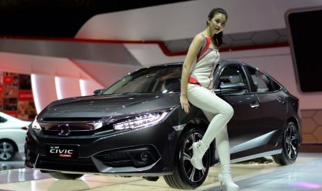 Model berpose di samping All New Honda Civic yang di pajang booth Honda di arena IIMS 2016 Kemayoran, Jakarta, Kamis (14/4).