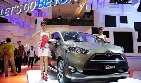 Model berpose di samping mobil terbaru sebuah kendaraan jenis  'multi activity vehicle' (MAV),  Toyota Sienta saat diperkenalkan di arena IIMS 2016 di Jakarta, Kamis (7/4). 