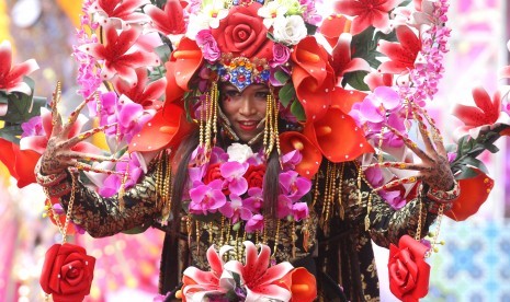 Model mempertontonkan keindahan busana bertema bunga anggrek dalam kegiatan Malang Fahion Flower Carnival dengan tema Eksotika Bunga Nusantara di Jalan Ijen, Malang, Jawa Timur, Minggu (10/9).