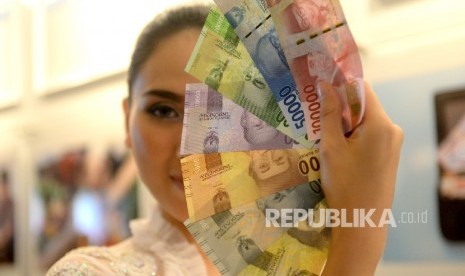 Model menunjukan uang Rupiah kertas wajah baru usai peresmian pengeluaran dan pengedaran uang Rupiah Tahu Emisi 2016 di Bank Indonesia, Jakarta, Senin (19/12). 