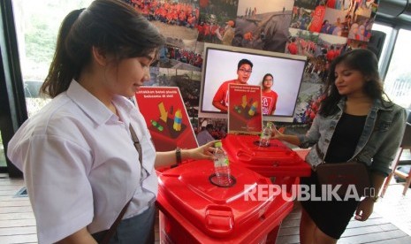 Model menunjukkan cara membuang sampah botol plastik saat peluncuran program Plastic Reborn yang diluncurkan Coca Cola di Jakarta, Selasa (27/2).