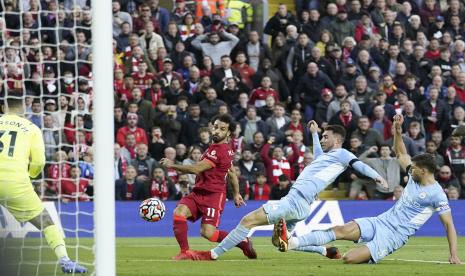 Mohamed Salah dari Liverpool mencetak keunggulan 2-1 melawan kiper Manchester City Ederson (kiri) selama pertandingan sepak bola Liga Premier Inggris antara Liverpool FC dan Manchester City di Liverpool, Inggris, Senin (4/10).