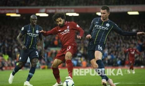 Mohamed Salah (kiri) ditempel ketat Aymeric Laporte pada pertandingan Liga Inggris antara Liverpool melawan Manchester City di Stadion Anfield, Liverpool, Senin (8/10)