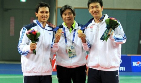 Mohammad Ahsan (kiri) bersama Hendra Setiawan mengapit pelatih mereka Heri Irman Pierngadi.