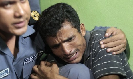 Mohammad Rafique, a Rohingya from Myanmar cries as an officer from the Bangladesh Coast Guard comforts him in Teknaf June 19, 2012. Bangladesh coast guard arrested Mohammad Rafique and his wife Amena Akhter with their two sons from Saint Martin's island, as they tried to get into Bangladesh via boat. Akter gave birth to her second son after being arrested on June 13. 