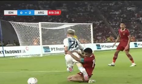 Momen gelandang Argentina Garnacho diadang bek Indonesia Asnawi Mangkualam saat pertandingan FIFA Match Day, Indonesia vs Argentina, Senin (19/6/2023).