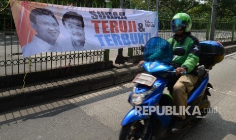 Motor melintas di sebelah spanduk duet Ahok-Djarot terpampang di Jalan Sultan Agung, Jakarta Pusat, Kamis (28/7). (Republika/ Yasin Habibi)