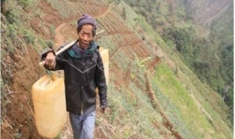 Mualaf di lerang Gunung Semeru sedang memikul air.