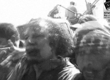 Muammad Qaddafi yang terluka masih bisa dberjalan. Foto diambil melalui ponsel seorang saksi mata.