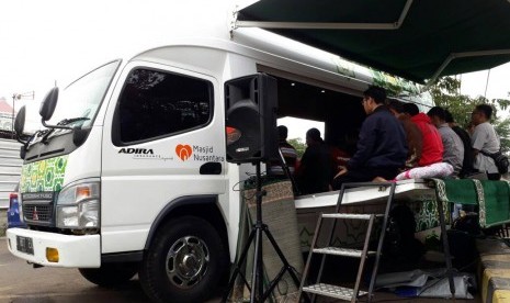 Muazin mengumandangkan azan Ashar di Mobile Masjid, Stasiun Pasar Senen, Jakarta, Sabtu (24/6).  