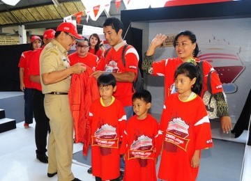 Mudik Kapal Laut: Walikota Makassar Ilham Arief Sirajuddin (kiri) memberikan jaket kepada peserta mudik akbar gratis TELKOMSELsiaga sebagai simbolisasi pelepasan mudik kapal laut di Pelabuhan Makassar