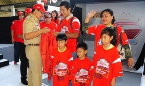 Mudik Kapal Laut: Walikota Makassar Ilham Arief Sirajuddin (kiri) memberikan jaket kepada peserta mudik akbar gratis TELKOMSELsiaga sebagai simbolisasi pelepasan mudik kapal laut di Pelabuhan Makassar