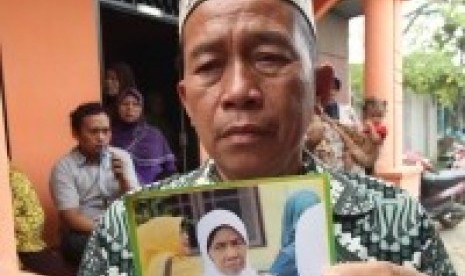 Muhammad Tayib (65 tahun) menunjukkan foto Almarhumah istrinya, Painem Dalio (62 tahun) korban tertimpa crane di Arab Saudi, di rumah duka Kawasan Jalan Mangaan V Medan, Sumatera Utara, Sabtu (12/9). 