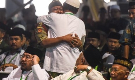 Muktamirin berpelukan dengan sorang anggota Banser seusai Rais Aam PBNU Mustofa Bisri memberikan fatwa saat pembahasan rancangan Tatib Muktamar NU ke-33 di alun-alun Jombang, Jawa Timur, Senin (3/8).