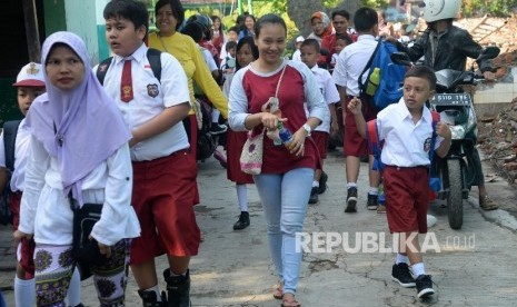 Orang tua mengantar anaknya ke sekolah 