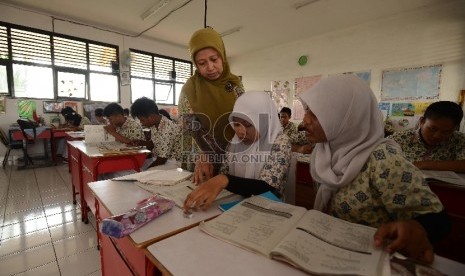 Murid kelas IX SMPN 65 melakukan kegiatan belajar mengajar di ruangan sementara di Sekolah Dasar Negeri 12 Pagi, Sunter Jakarta Utara, Kamis (16/4).(Republika/Raisan Al Farisi).