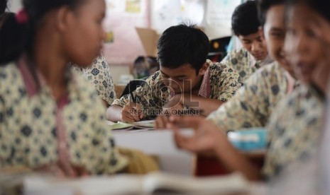 Murid kelas IX SMPN 65 melakukan kegiatan belajar mengajar di ruangan sementara di Sekolah Dasar Negeri 12 Pagi, Sunter Jakarta Utara, Kamis (16/4).(Republika/Raisan Al Farisi).