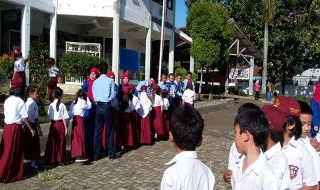 Murid-murid SD Bosowa Bina Insani Bogor bersalaman dengan para guru mereka pada halal bihalal Idul Fitri 1436 H.