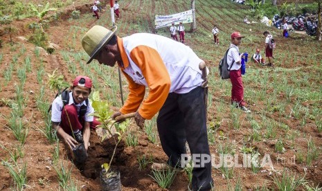  Pemerintah Provinsi Jawa Barat sedang menyusun peraturan agar warga berperan aktif menanam pohon di lahan kritis di Jawa Barat.  Foto: Murid SD bersama petani menanam pohon di area perkebunan di Kawasan Bandung Utara (KBU), Desa Cimenyan, Kabupaten Bandung, Senin (9/12).