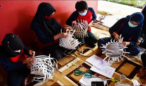 Murid Sekolah Luar Biasa (SLB) mengikuti pelatihan membuat tas anyaman berbahan tali strapping di SLB Dharma Wanita Jiwan, Kabupaten Madiun, Jawa Timur, Senin (27/12/2021). Sebanya 25 murid SLB tingkat SD, SMP dan SMA gabungan dari dua SLB mengikuti kegiatan tersebut selama tiga hari guna mendapatkan keterampilan menganyam tas, sehingga diharapkan setelah lulus mereka bisa bekerja secara mandiri.