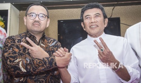 Musisi dangdut Rhoma Irama (kanan) didampingi Calon Gubernur Jawa Tengah Sudirman Said (kiri) memberikan salam dua jari seusai memberikan keterangan pers mengenai Pilkada Jawa Tengah di Jakarta, Selasa (27/3).